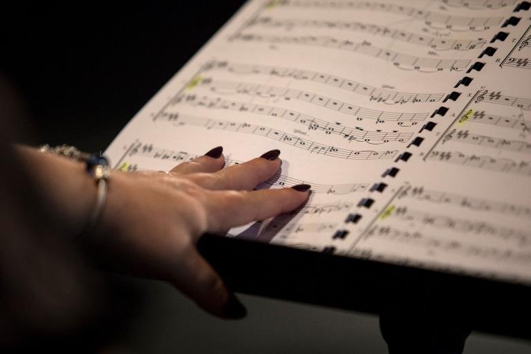 Une main de femme se pose sur une partition de musique